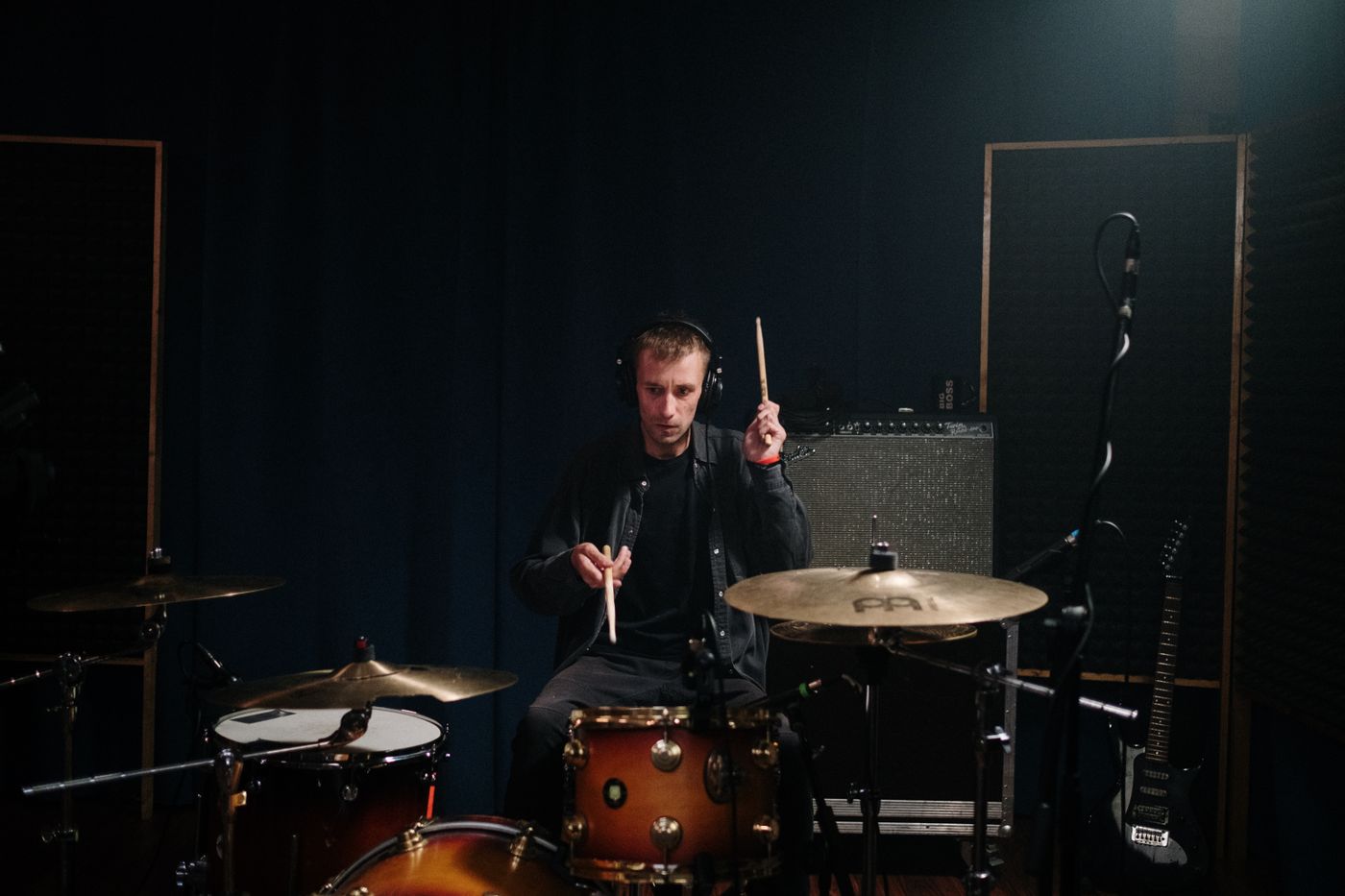 A drummer playing a kit in a recording studio