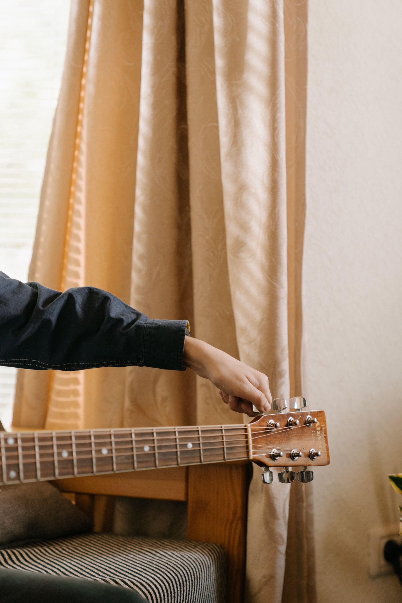 A musician tuning an acoustic guitar