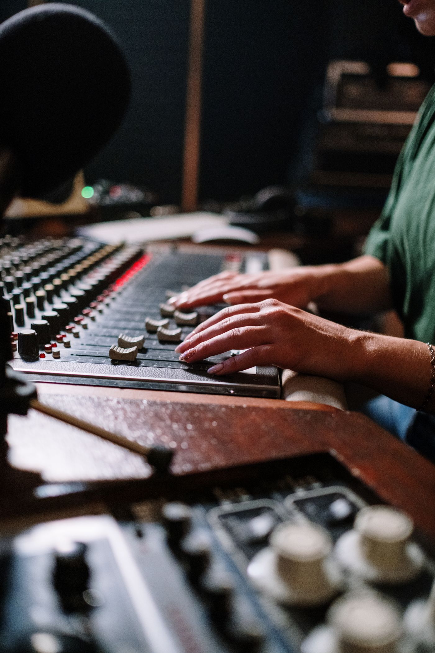 Hands adjusting levels on a mixing desk