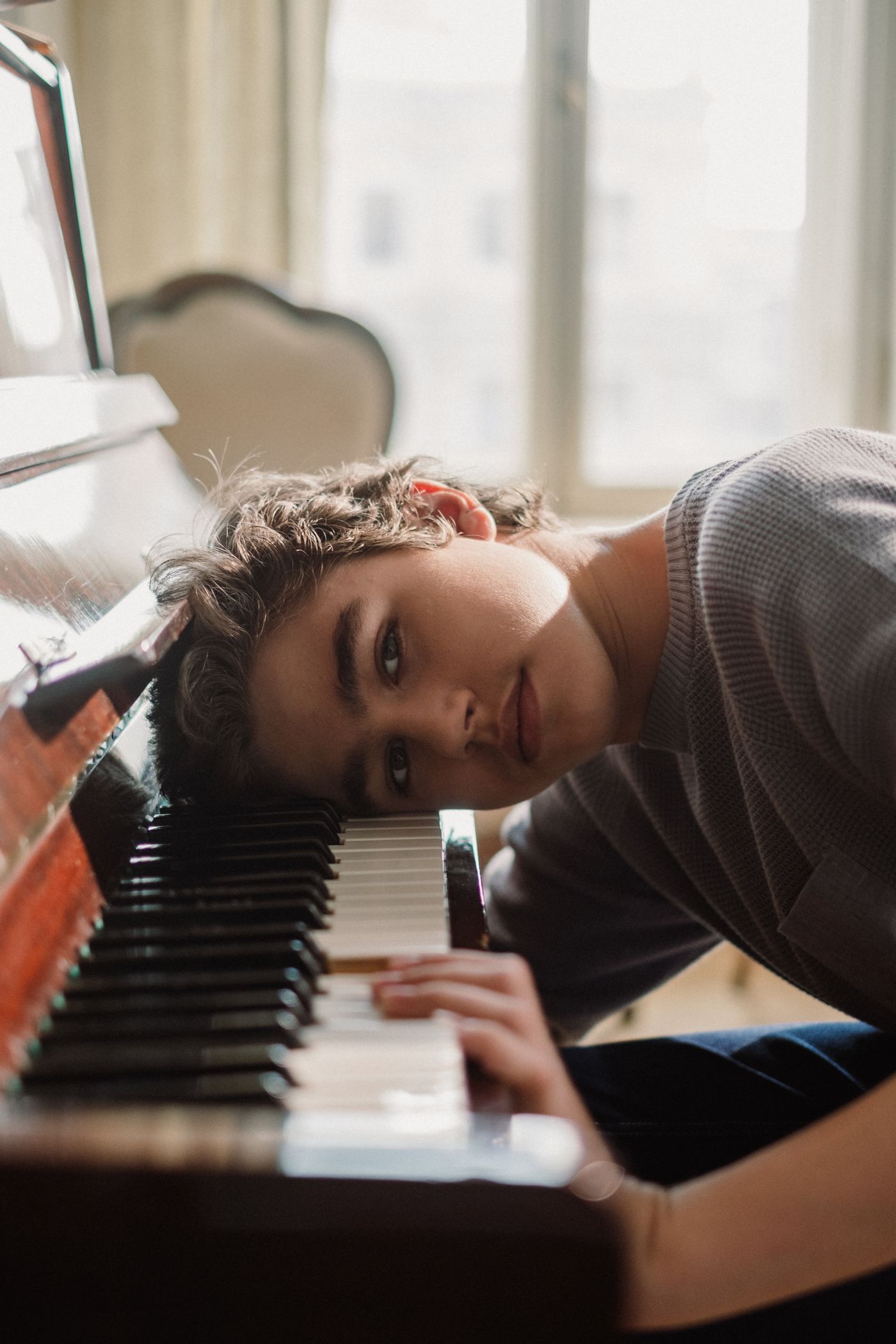 A musician resting beside a grand piano