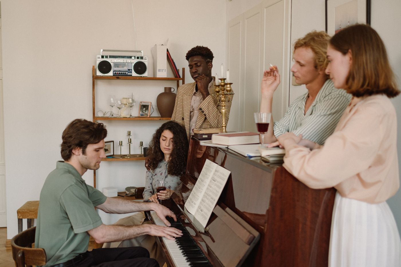 Friends listening to music around a piano