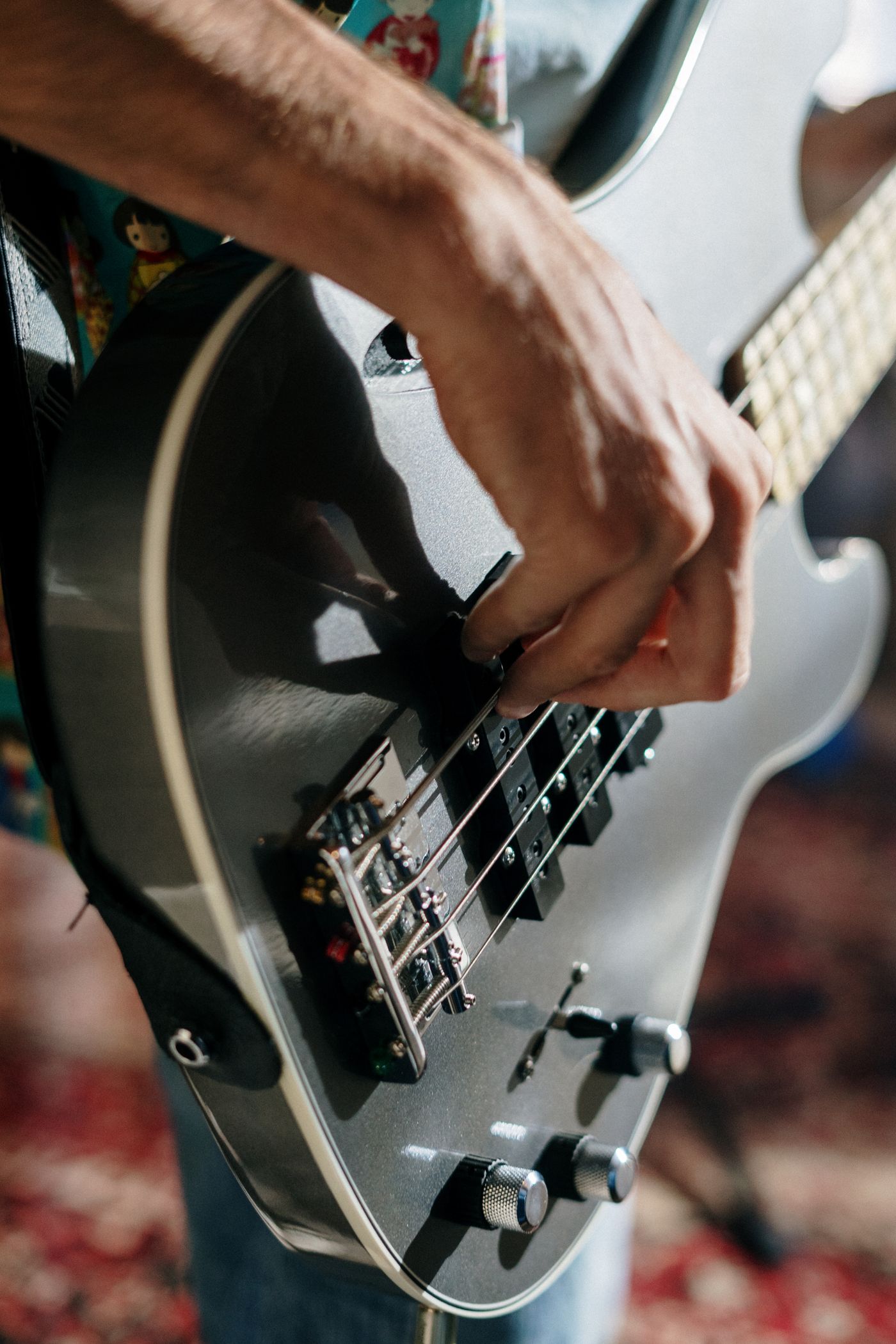 A close view of a hand playing a white electric guitar