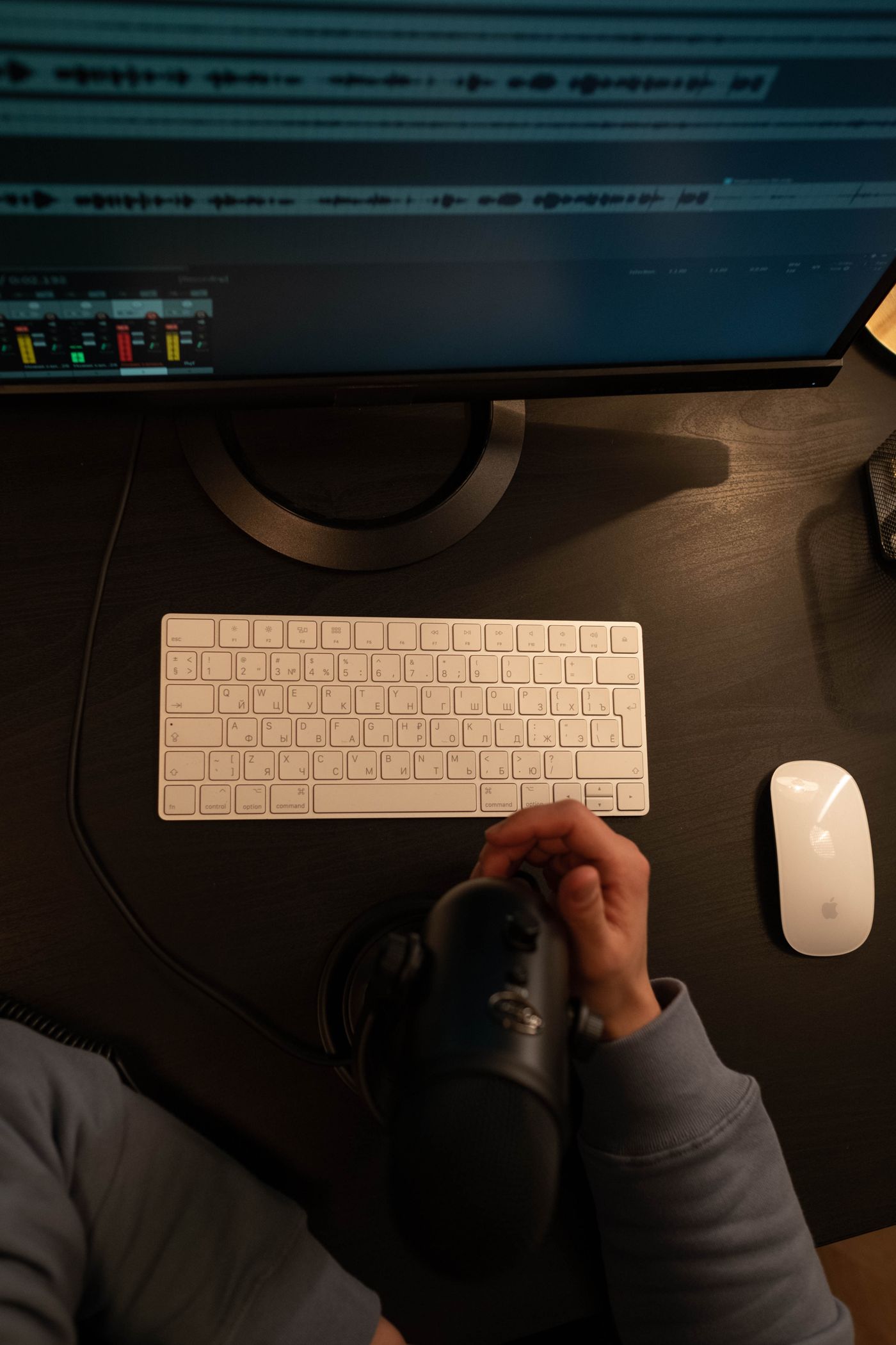 A microphone beside a computer recording workspace