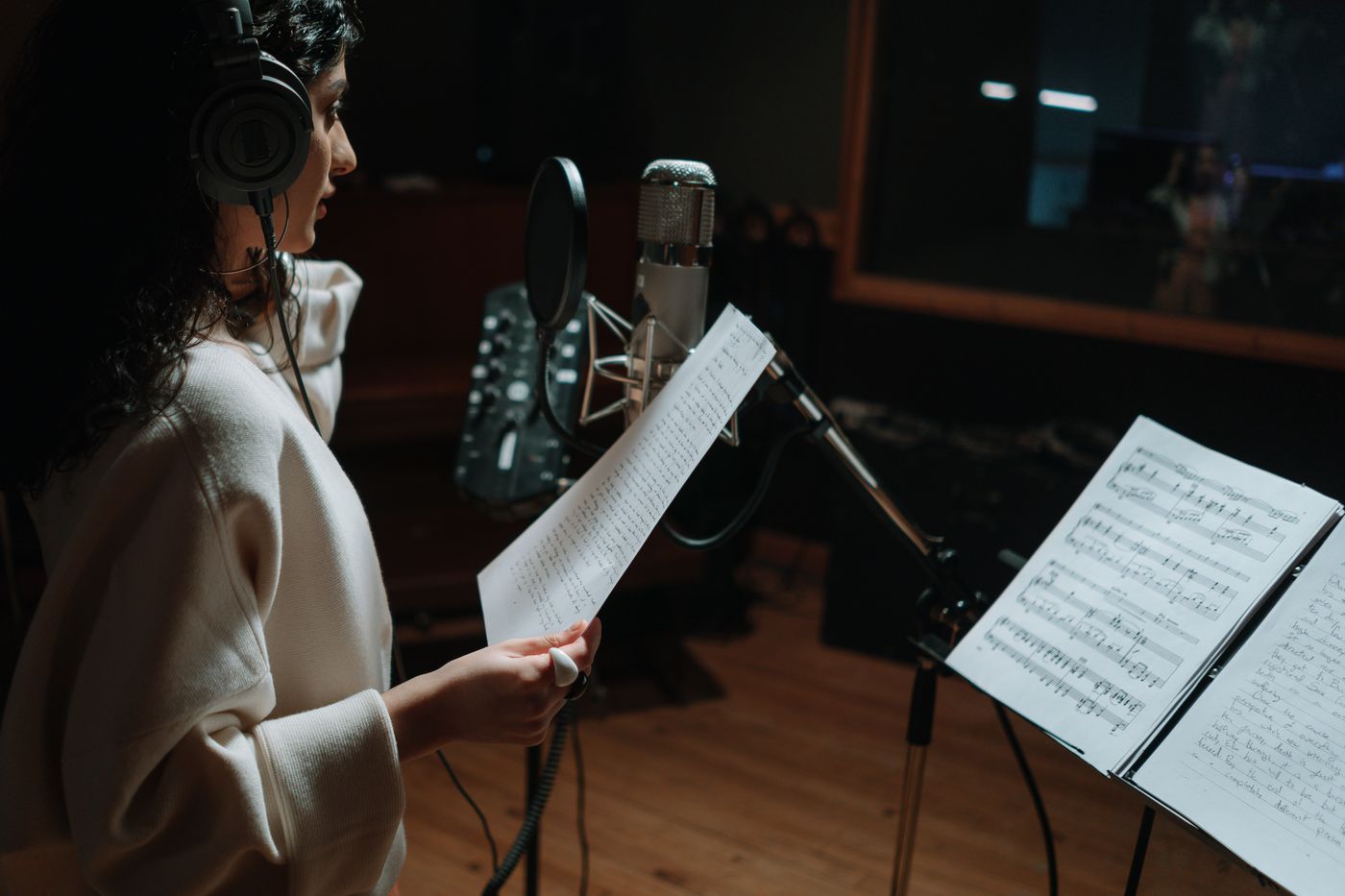 A vocalist recording beside a music stand