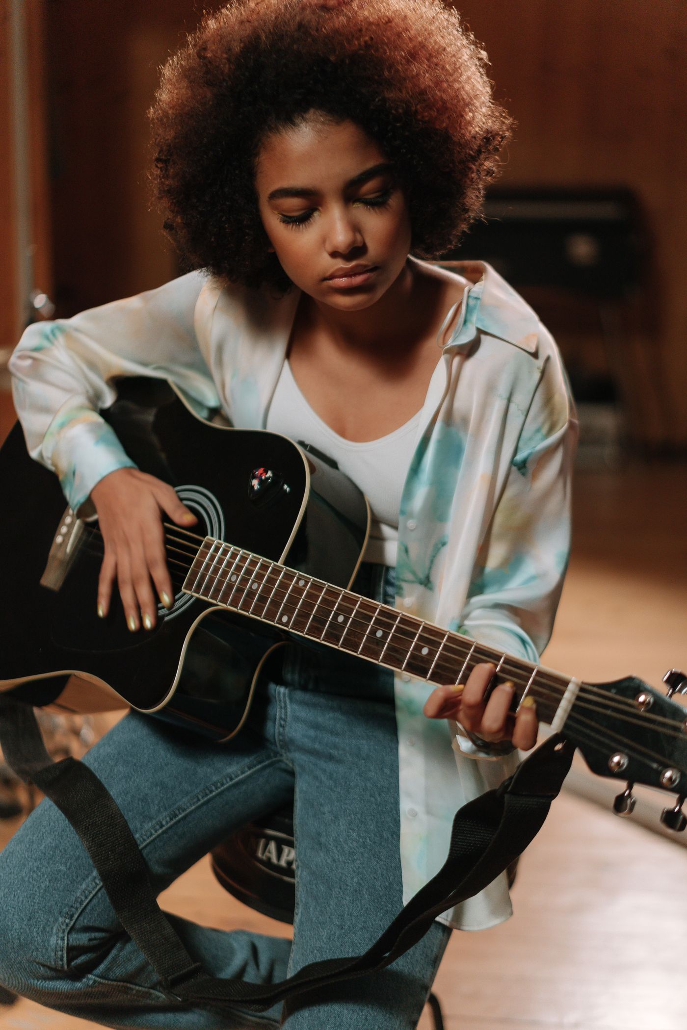 A musician playing an acoustic guitar in a studio