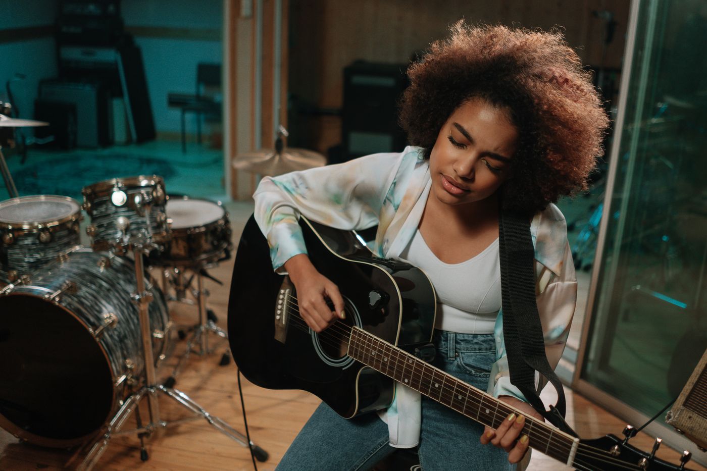 A guitarist performing beside studio equipment