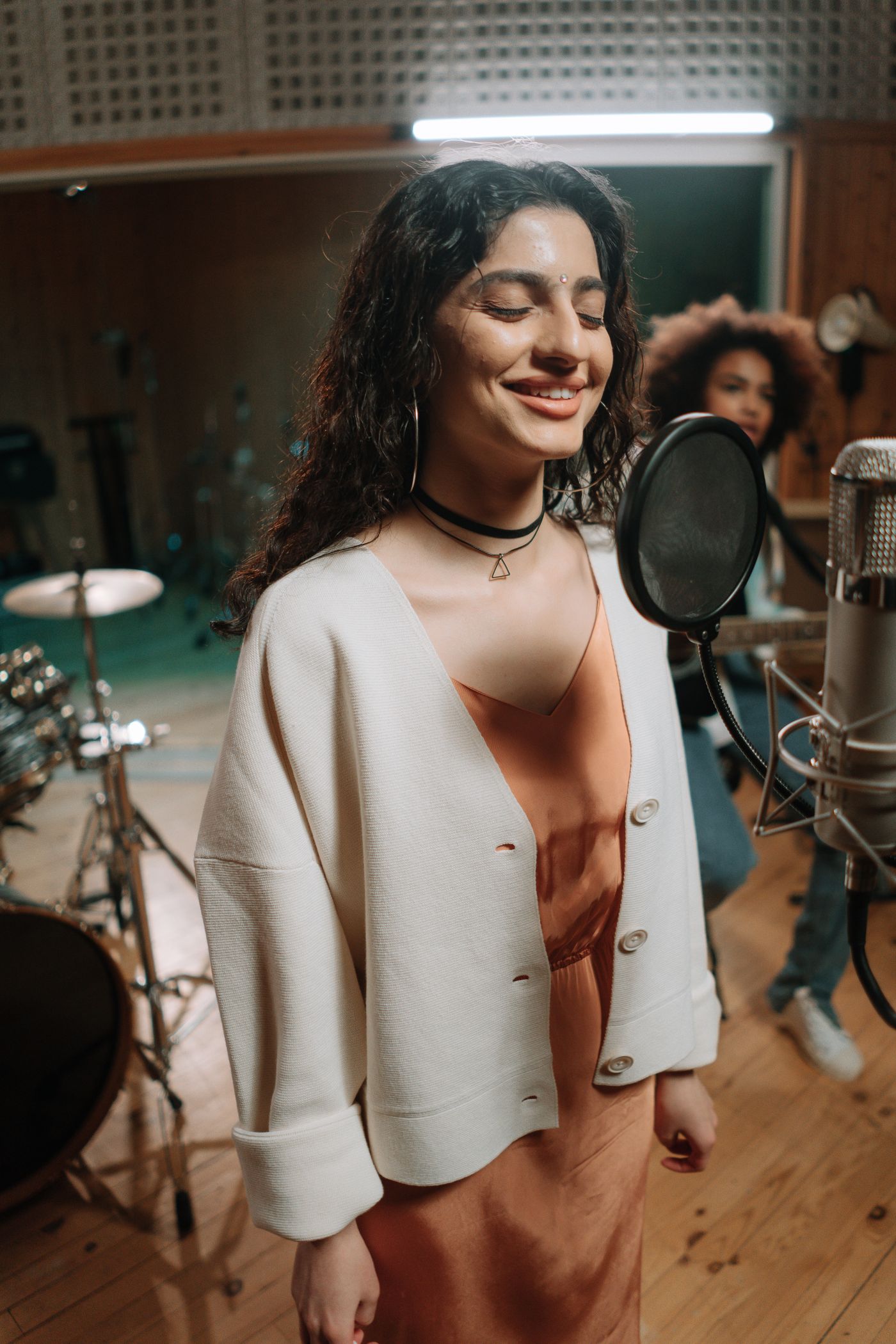A musician singing with headphones in a music studio