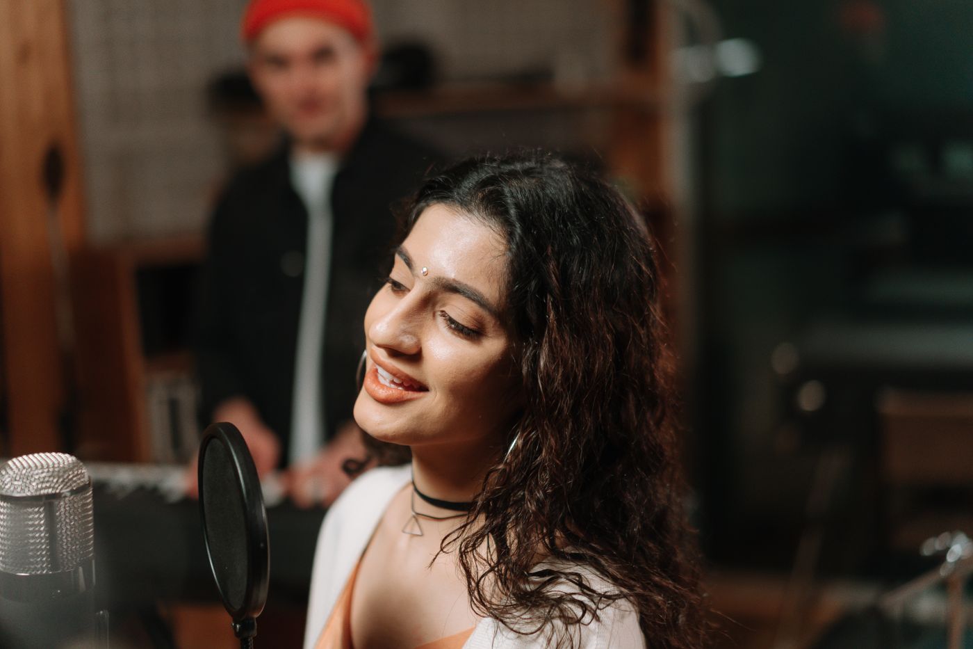 A singer smiling during a studio recording