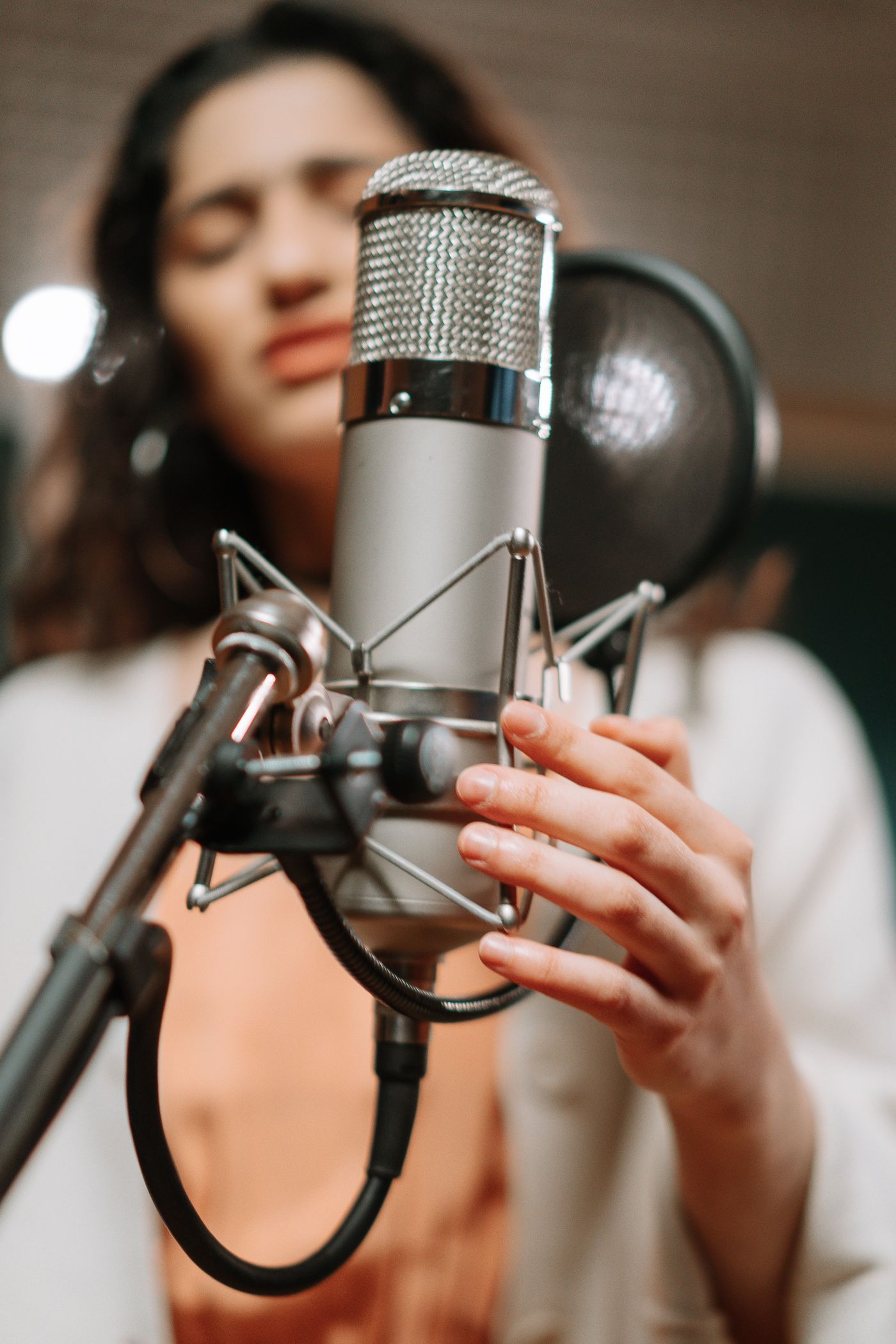 A vocalist performing into a studio microphone