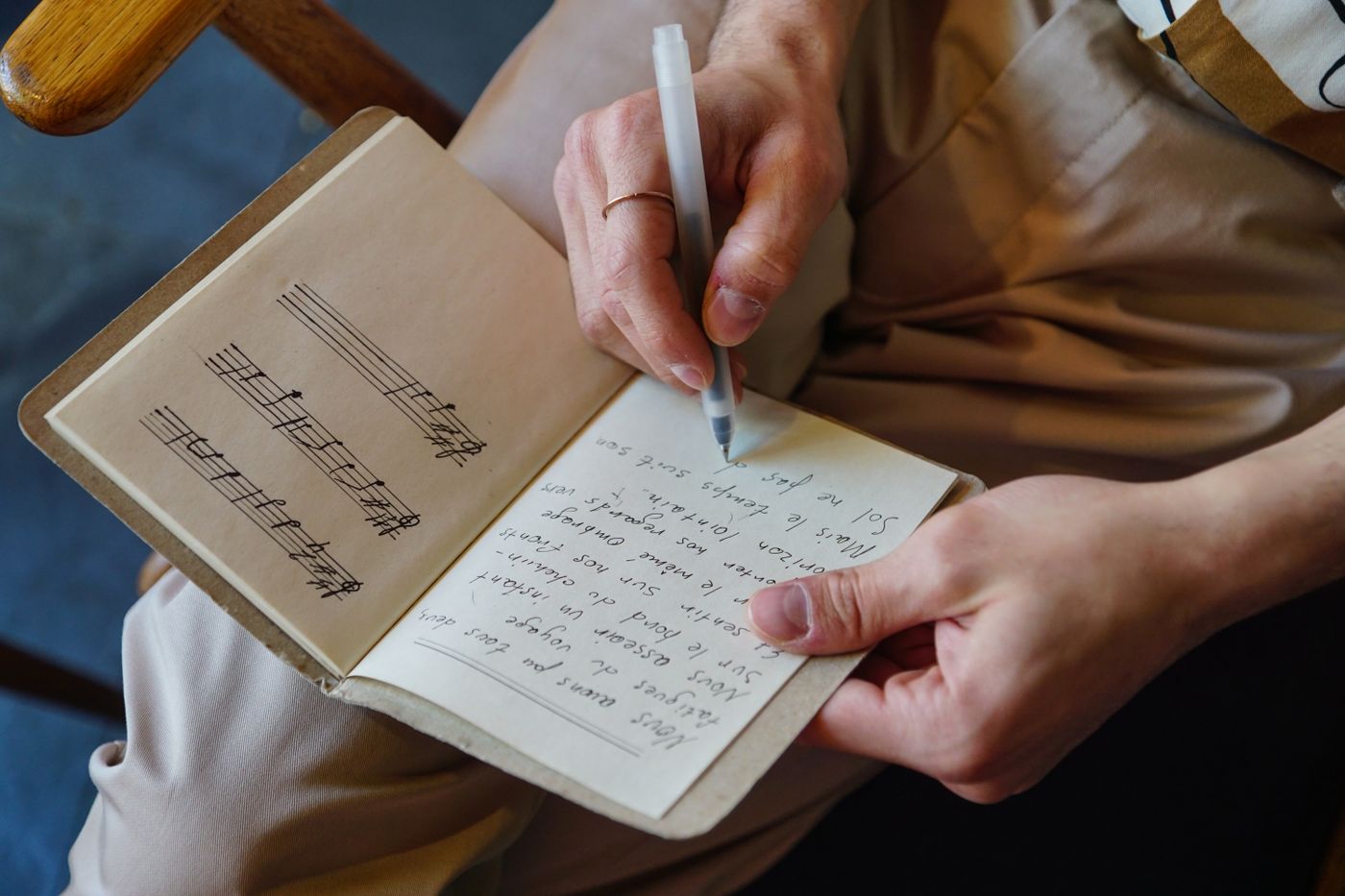 A songwriter writing notes in a notebook