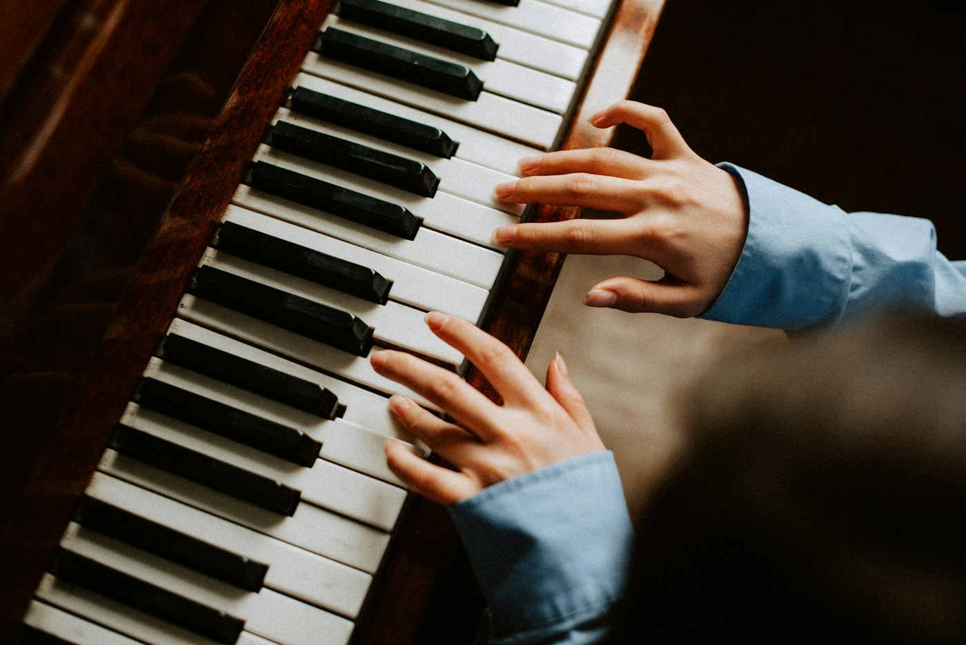 Hands playing a piano keyboard